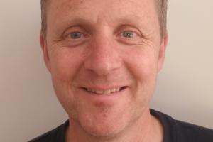 Dr Julian Owen mewn top tywyll