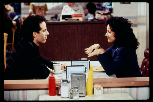 two Seinfeld characters chat in the cafe location in the show