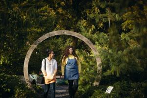 two students walk  among trees at Treborth Botanic Garden, Bangor University