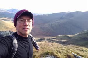 Man standing with beautiful rolling mountains behind him