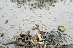 A muddy foreshore littered with rubbish