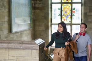 Two students walking up the stairs in Bangor University's Main Arts building