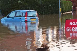 Car wedi ei amgylchynnu gan ddwr ac arwydd Lon wedi cau.