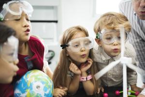 group of children taking part in a demonstration of wind power