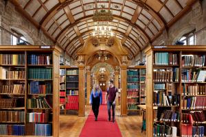 Image of two students walking through the centre of one of Bangor's beautiful libraries.