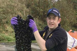 Image of Dr Nick Jones holding up mussels