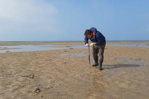 Professor Christian Dunn taking samples on a beach
