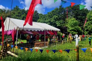 outdoors tent, grass and tree background, people playing games. 