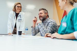 Clinicians sitting around a table smiling