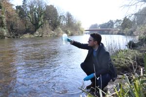 man looks at jarfull of water  scooped from river