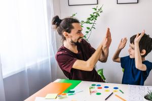 Boy playing learning games with man