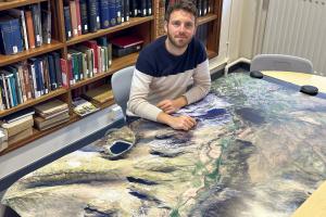 Person sitting at a desk with a map