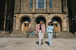 Two students walking in the quad 