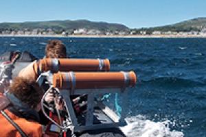 Researchers on a boat sampling the waters surrounding the Isle of Man
