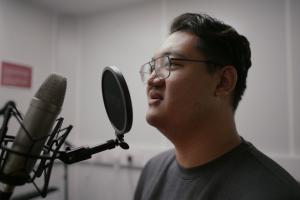 Student speaking into mic in phonetics lab