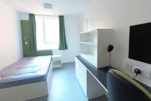 St Mary's Premium En-suite with a bed, desk, shelves and a chair