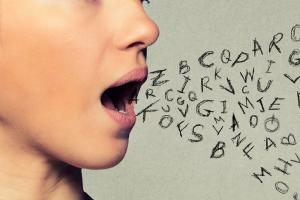 Representation of language - girl speaking with mixed letters displayed from her mouth