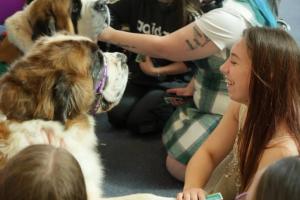a group of students petting a dog as a fundraising activity.
