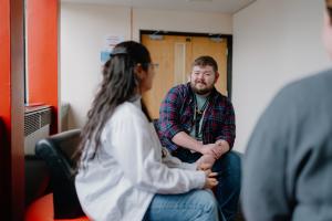 Myfyriwr yn cyfarfod ac yn siarad ag aelod o staff