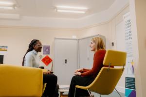 Myfyriwr yn cyfarfod ac yn siarad ag aelod o staff