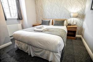 modern hotel room with double bed in white and grey with a pattern accent wall