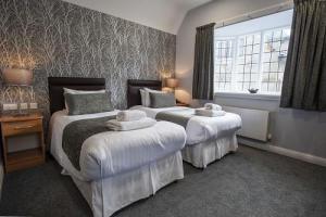 Modern room with two single beds next to each other, white crisp linen, big window and lots of natural light