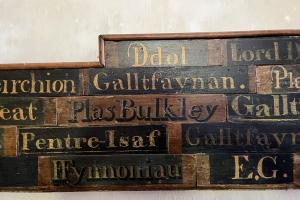 A series of name plates in different fonts, including Ddol, Galltfaynan, Plas Bulkley, Pentre-Isaf