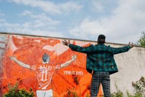 Wales wal graffiti of Gareth Bale and student standing in front
