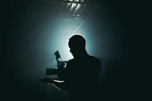 Filmmaker in the dark with spotlight from behind 