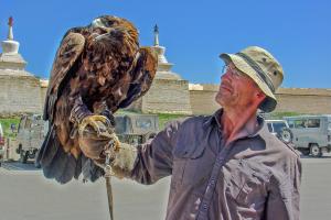 Charles Bishop holding a large bird of prey in Mongolia