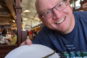 John Mulley holding a plate with a fried lamprey on it