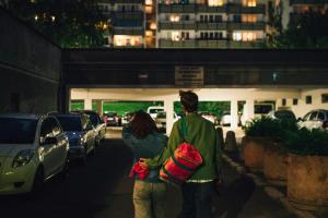 Image of couple walking away towards a car park