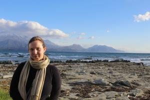 Daniela De Angeli Dutra standing on a beach with sea and mountains behind