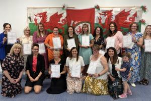 A group of women standing and holding certificates