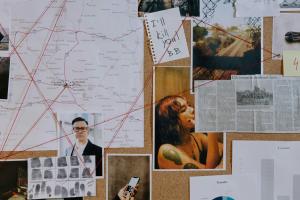 Murder Investigation image of pin board of map, image of man, woman and finger prints