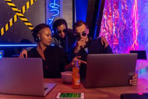 Three young individuals looking at a laptop attempting to resolve a crime