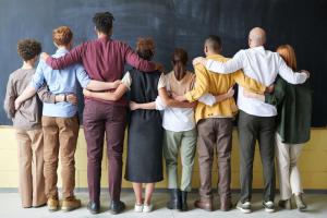 Row of idividuals linking arms facing away from the camera