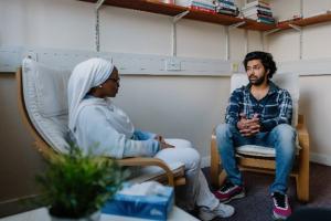 Image of two people sat in a room having a conversation