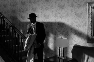 Black and white image of male in a living room 