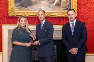 Dr Libby Steele being presented with her trophy by Alliance President, HRH The Duke of Edinburgh, alongside a representative from Pri0r1ty Intelligence Group.