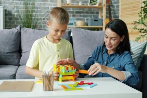 An adult is helping a child with a puzzle