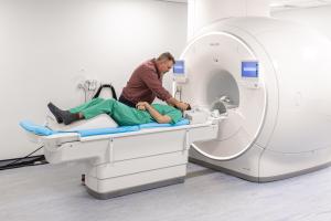 A person is being prepared to enter the MRi scanner