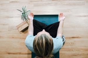 A bird's eye view of a person sitting on a mat meditating