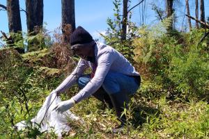 Person kneeling down and lifting a white net