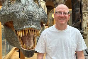 John Mulley standing next to a dinosaur