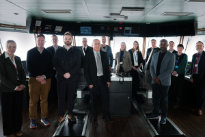 A large group of people standing for a photo aboard a research vessel 