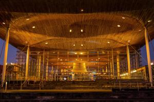 The Senedd (Welsh Parliament) at night, illuminated with warm ambient lighting.