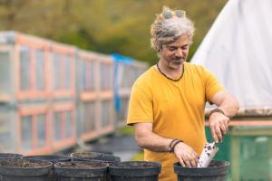 Photo of man potting tree in tree nursery
