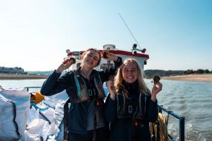 Two scientists holding oysters