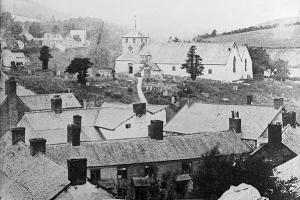Ffotograff du a gwyn o bentref Ysbyty Ifan, wedi'i dynnu o fantais uchel. Mae toeau tai yn y blaendir ac eglwys yn y pellter.